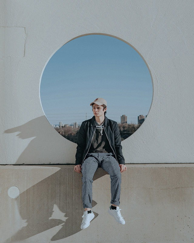 壁際に座る男性