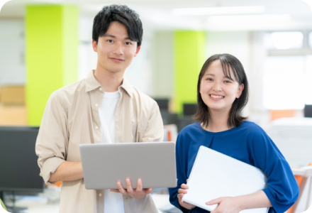 PCを持って微笑む男女